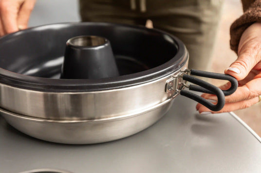 Eine Person öffnet Campinggeschirr von Petromax