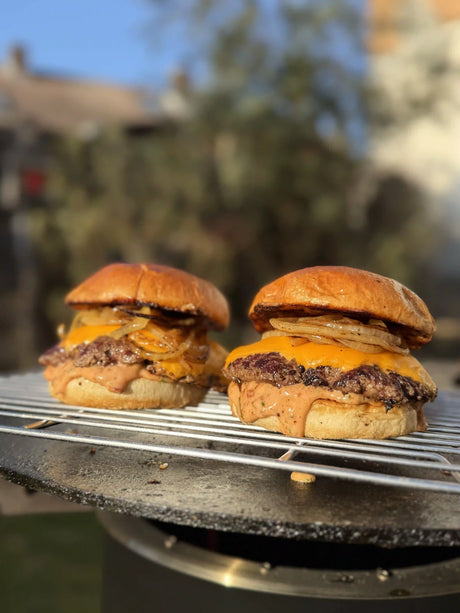 Smashed Baconnaise Burger mit knusprigem Rindfleisch-Patty, geschmolzenem Käse, Bacon-Sauce und geröstetem Bun vom Grill