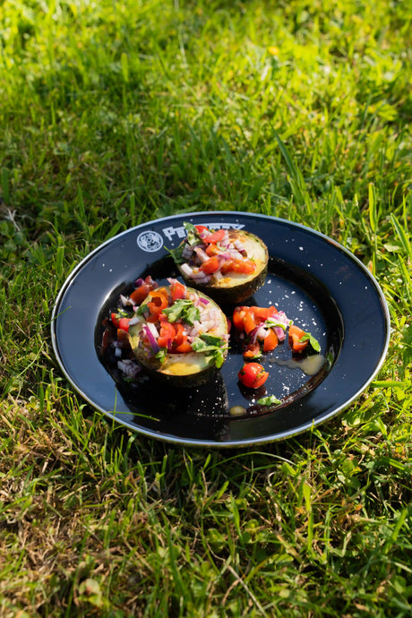 Gegrillte Avocadohälften mit frischem Pico de Gallo aus Tomaten, roter Zwiebel, Chili, Limette und Koriander.